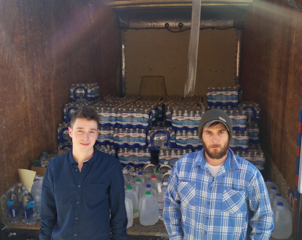 two men packing cases of water